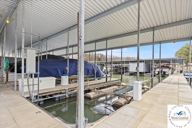 dock area with boat lift and a water view