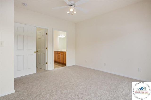 unfurnished bedroom with a ceiling fan, light colored carpet, baseboards, and ensuite bathroom