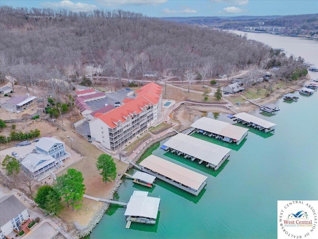 drone / aerial view with a water view and a wooded view