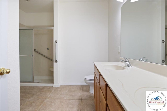 bathroom featuring double vanity, toilet, a stall shower, and a sink