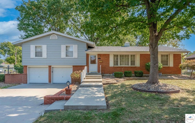 tri-level home featuring a garage, driveway, brick siding, and a chimney