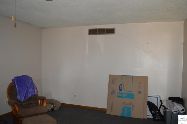 living area with visible vents, a textured ceiling, and baseboards