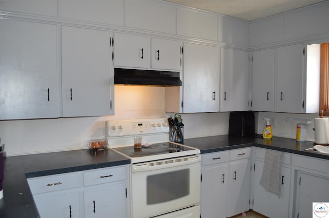 kitchen with dark countertops, electric range, white cabinets, and under cabinet range hood