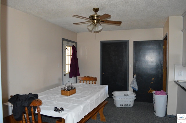 carpeted dining area with a textured ceiling and ceiling fan