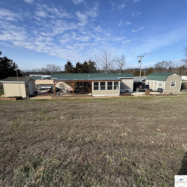 33039 Hilty Ave, Warsaw, MO 65355 - back of house with an outdoor structure, metal roof, a yard, and a shed