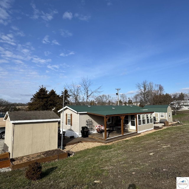 33039 Hilty Ave, Warsaw, MO 65355 - back of house featuring a storage unit, a yard, metal roof, and an outbuilding