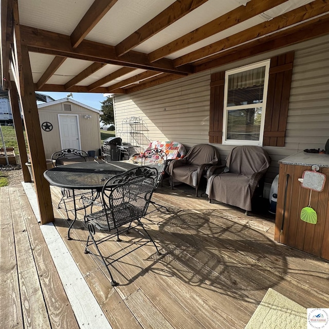 33039 Hilty Ave, Warsaw, MO 65355 - wooden terrace with outdoor dining space, a shed, and an outbuilding