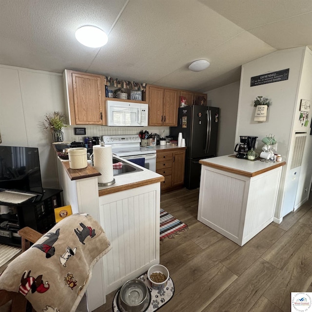 33039 Hilty Ave, Warsaw, MO 65355 - kitchen with vaulted ceiling, a peninsula, wood finished floors, and white appliances