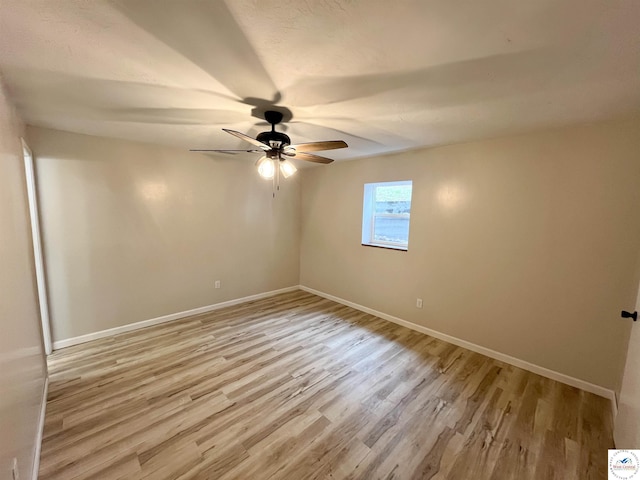 empty room with ceiling fan, light wood-type flooring, and baseboards