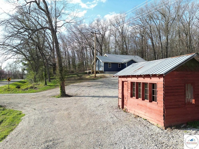view of home's exterior with driveway and metal roof