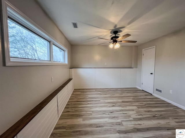 unfurnished room featuring a ceiling fan, visible vents, and wood finished floors