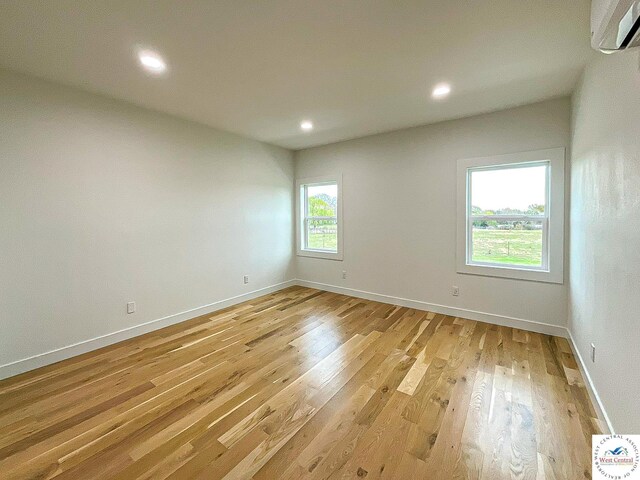 17788 Main Rd, Sedalia, MO 65301 - empty room featuring an AC wall unit, light wood-style floors, recessed lighting, and baseboards