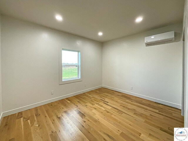 17788 Main Rd, Sedalia, MO 65301 - spare room featuring an AC wall unit, light wood-style floors, recessed lighting, and baseboards