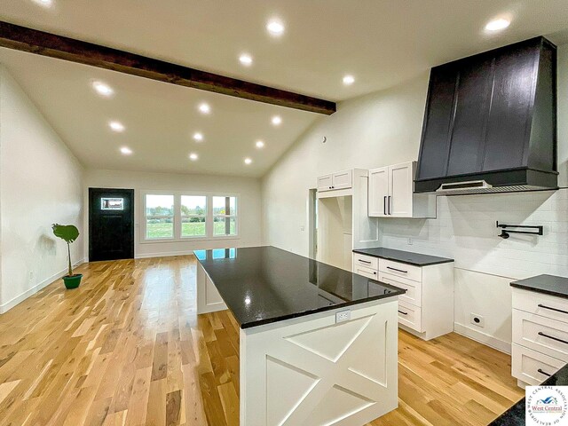 17788 Main Rd, Sedalia, MO 65301 - kitchen with light wood-style flooring, white cabinetry, a kitchen island, backsplash, and ventilation hood