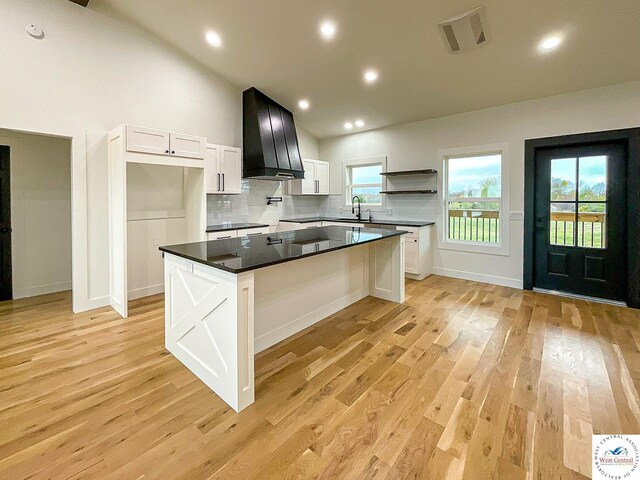 17788 Main Rd, Sedalia, MO 65301 - kitchen with open shelves, range hood, dark countertops, vaulted ceiling, and white cabinets
