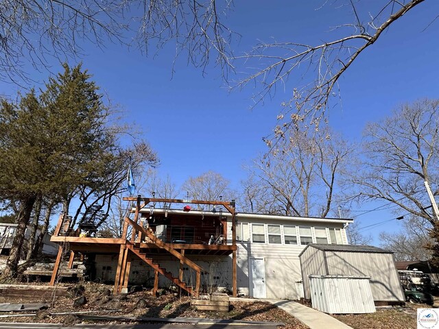 rear view of house featuring stairway and a wooden deck