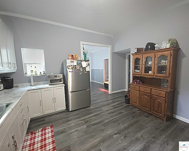 1012 E 7th St, Sedalia, MO 65301 - kitchen featuring freestanding refrigerator, ornamental molding, dark wood-type flooring, white cabinets, and baseboards