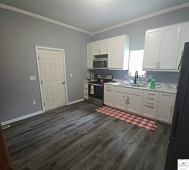 1012 E 7th St, Sedalia, MO 65301 - kitchen featuring stainless steel appliances, a sink, ornamental molding, white cabinetry, and dark wood-style floors