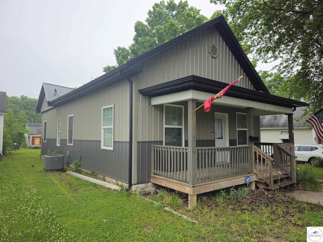1012 E 7th St, Sedalia, MO 65301 - bungalow-style house with covered porch, central AC, a front lawn, and board and batten siding