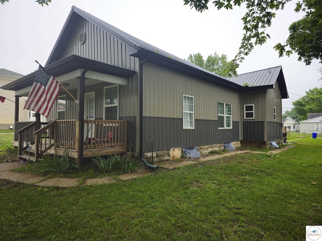 1012 E 7th St, Sedalia, MO 65301 - view of side of property featuring a yard, a porch, board and batten siding, and metal roof