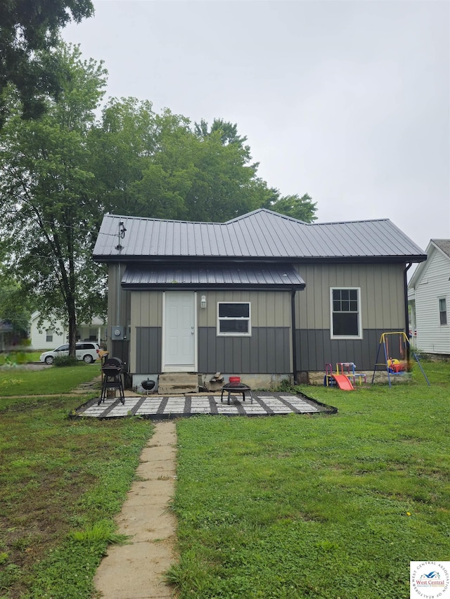 1012 E 7th St, Sedalia, MO 65301 - rear view of property with board and batten siding, a yard, and metal roof