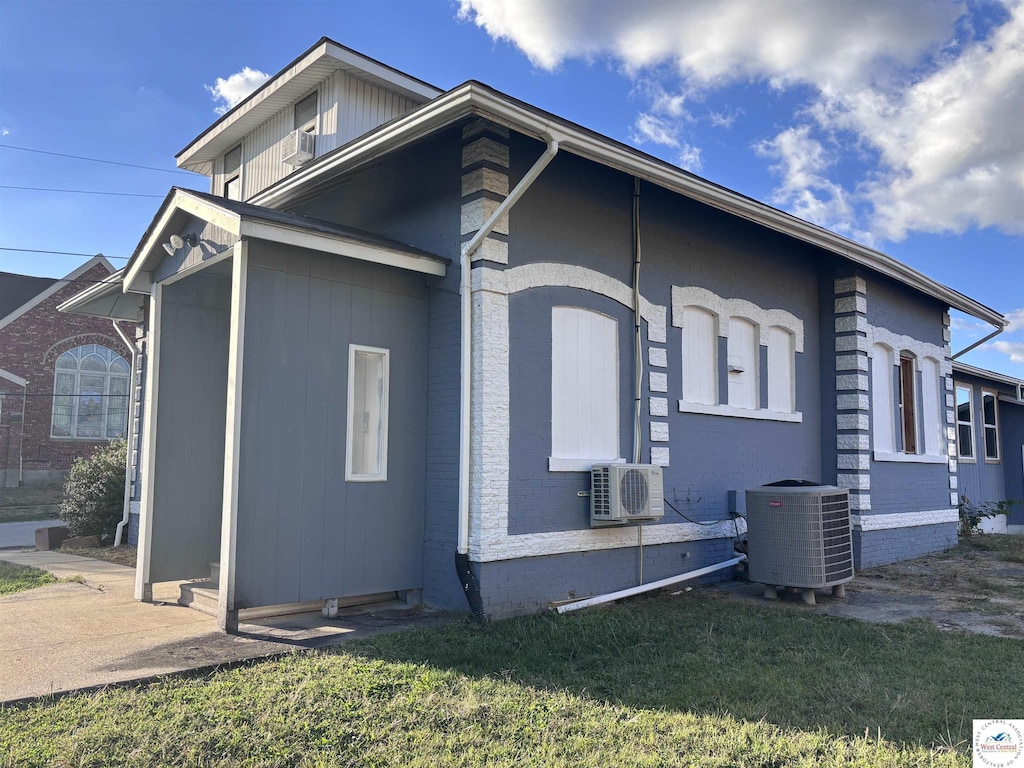 view of home's exterior with a lawn, central air condition unit, ac unit, and brick siding