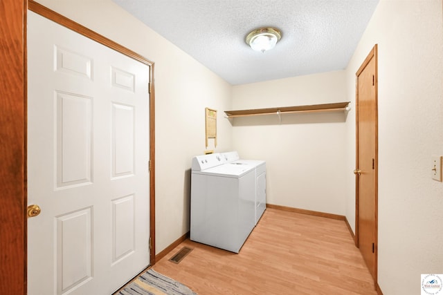 56 NW 247th Rd, Clinton, MO 64735 - laundry room with independent washer and dryer, light wood-style floors, and a textured ceiling