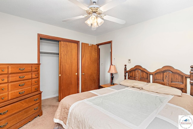 bedroom with ceiling fan, light carpet, and a closet