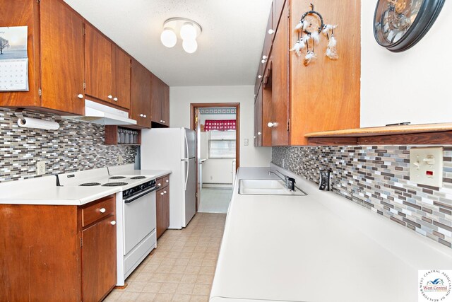 kitchen with light floors, white appliances, decorative backsplash, and a sink