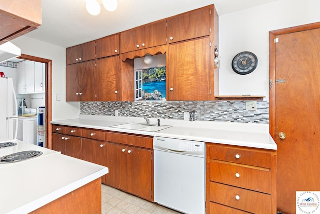 kitchen featuring brown cabinets, a sink, white appliances, tasteful backsplash, and light countertops