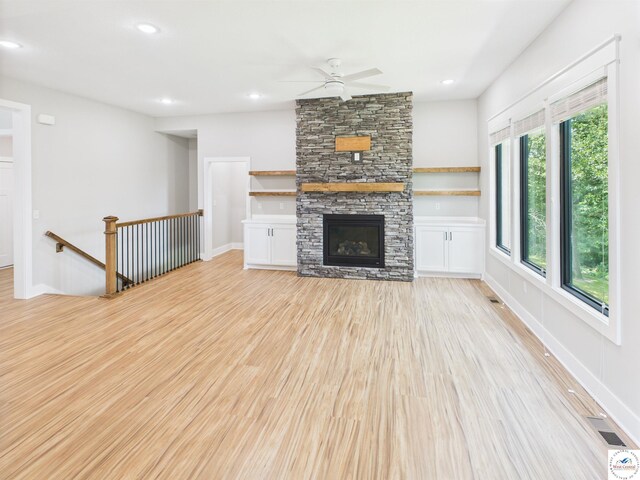 1248 Rich Blvd, Warrensburg, MO 64093 - unfurnished living room with light wood finished floors, a ceiling fan, a stone fireplace, and recessed lighting