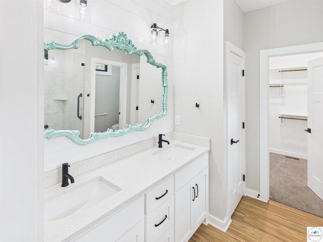 1248 Rich Blvd, Warrensburg, MO 64093 - bathroom with a spacious closet, a stall shower, double vanity, and wood finished floors