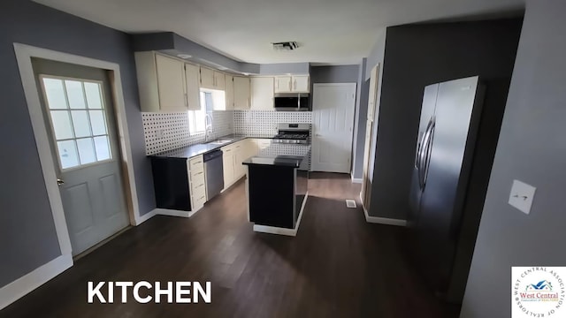 501 S Oak St, Versailles, MO 65084 - kitchen featuring appliances with stainless steel finishes, backsplash, dark wood-style floors, a center island, and white cabinets