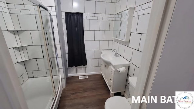 501 S Oak St, Versailles, MO 65084 - full bath featuring tile walls, a shower stall, vanity, and wood finished floors