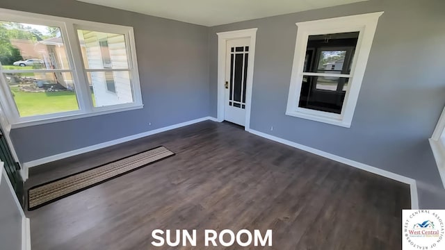 501 S Oak St, Versailles, MO 65084 - empty room with healthy amount of natural light and dark wood-style floors