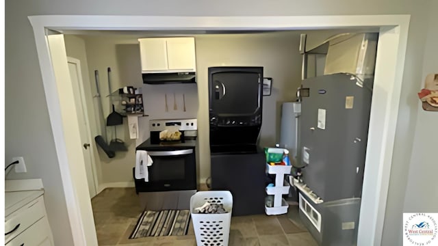 107 W Benton St, Clinton, MO 64735 - kitchen with under cabinet range hood, stainless steel electric range, white cabinets, and light countertops