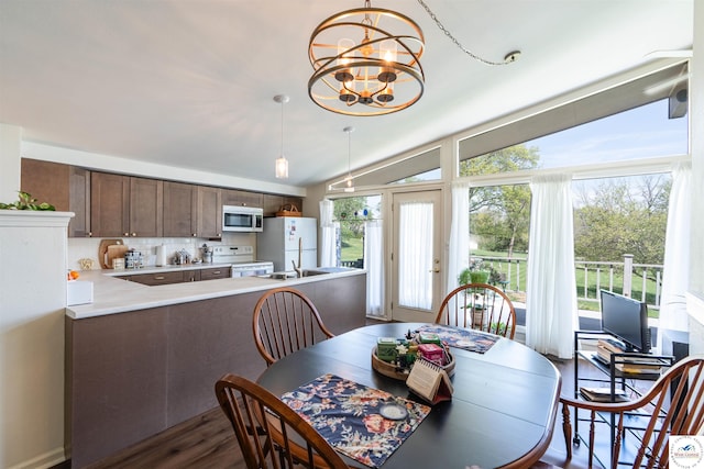 7020 Walnut Cir, Sedalia, MO 65301 - dining space featuring dark wood-style flooring, a notable chandelier, and vaulted ceiling