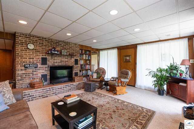 7020 Walnut Cir, Sedalia, MO 65301 - carpeted living room with a brick fireplace, a paneled ceiling, and wooden walls