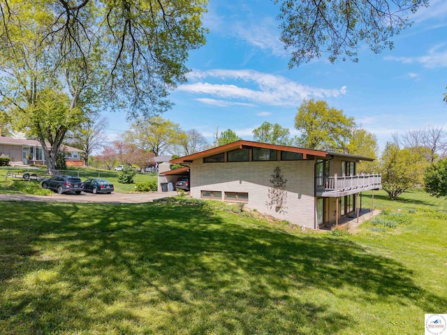 7020 Walnut Cir, Sedalia, MO 65301 - view of home's exterior with brick siding, a yard, and a deck