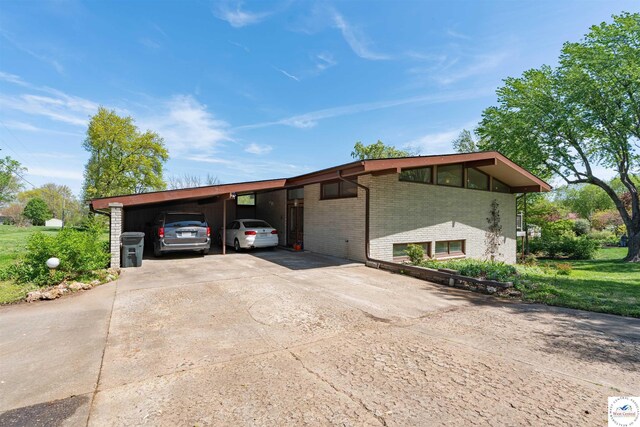 7020 Walnut Cir, Sedalia, MO 65301 - view of front of house with brick siding, driveway, and an attached carport