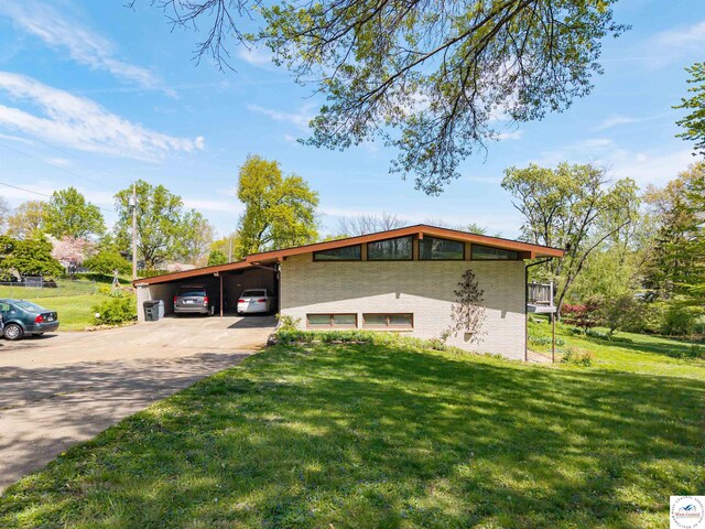 7020 Walnut Cir, Sedalia, MO 65301 - view of front of property with brick siding, a front lawn, concrete driveway, and an attached carport