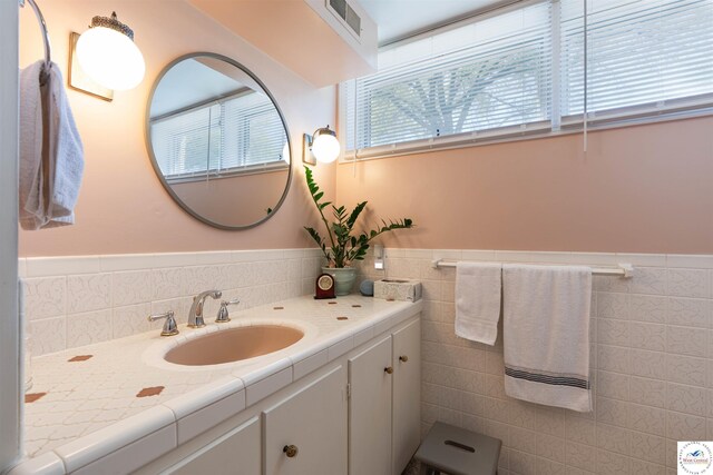 7020 Walnut Cir, Sedalia, MO 65301 - bathroom featuring a wainscoted wall, visible vents, and tile walls