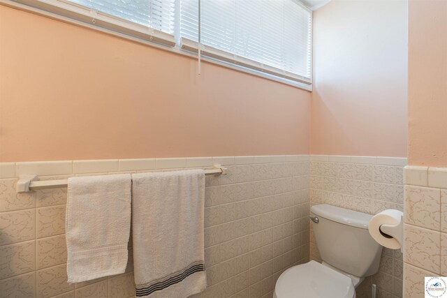 7020 Walnut Cir, Sedalia, MO 65301 - bathroom featuring wainscoting, tile walls, and a wealth of natural light
