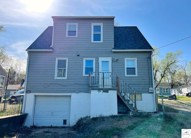 607 Laurel St, Warrensburg, MO 64093 - back of house with fence, a shingled roof, and a garage