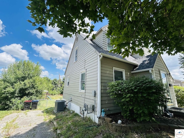 607 Laurel St, Warrensburg, MO 64093 - view of side of home with a cooling unit and a shingled roof