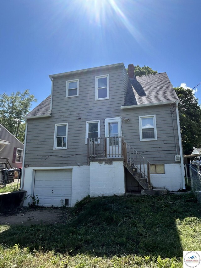 607 Laurel St, Warrensburg, MO 64093 - rear view of house featuring a garage, a chimney, and a shingled roof