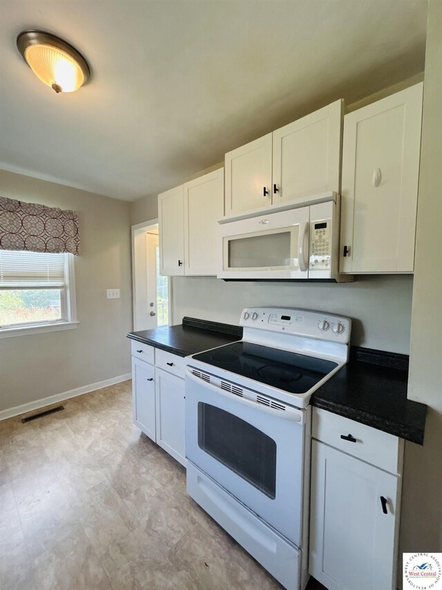 607 Laurel St, Warrensburg, MO 64093 - kitchen featuring white appliances, dark countertops, and white cabinets
