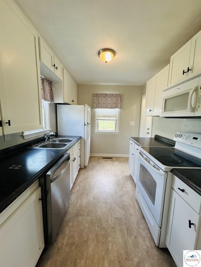607 Laurel St, Warrensburg, MO 64093 - kitchen with white appliances, dark countertops, white cabinets, and light floors