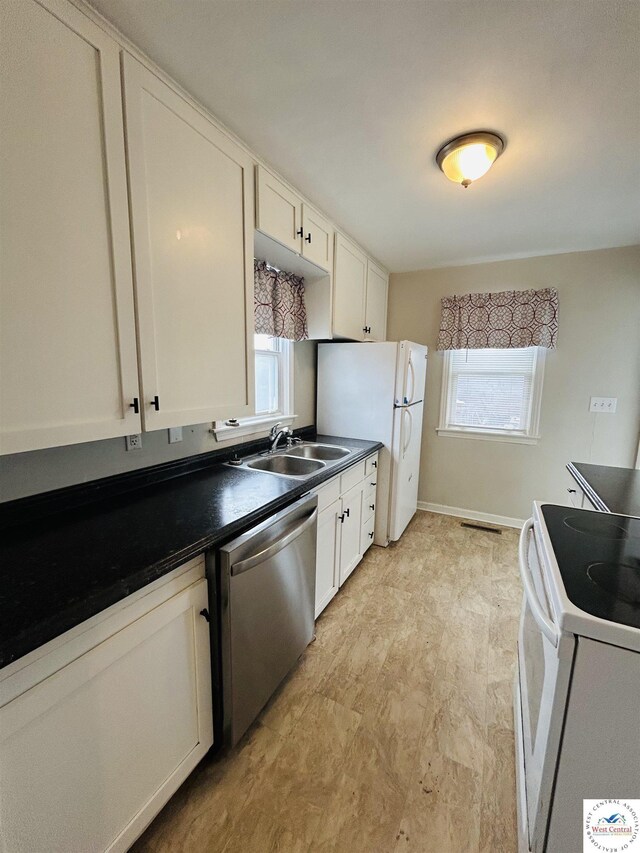 607 Laurel St, Warrensburg, MO 64093 - kitchen featuring dark countertops, a sink, a wealth of natural light, and white appliances
