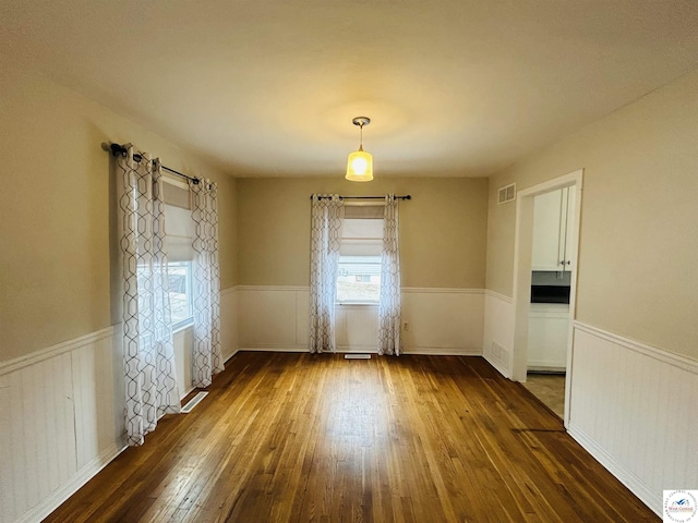 607 Laurel St, Warrensburg, MO 64093 - empty room with dark wood-style floors, wainscoting, and visible vents